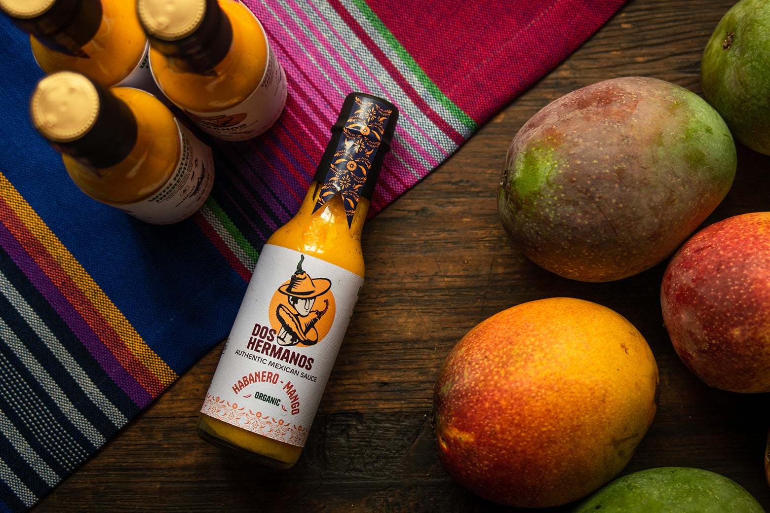 authentic, handmade, habanero-mango hot suace in table with mangos