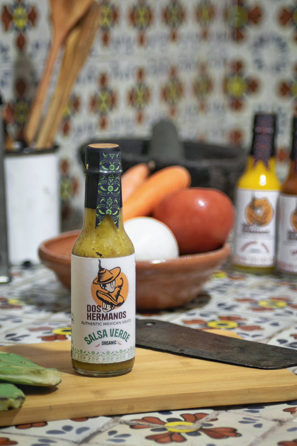 Dos Hermanos Salsa Verde bottle.

Salsa verde being scooped with a tortilla chip.

Ingredients used to make salsa verde.